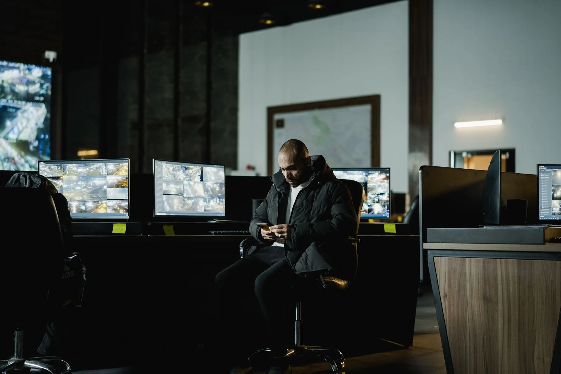 An engineer monitoring systems from a darkened operations room
